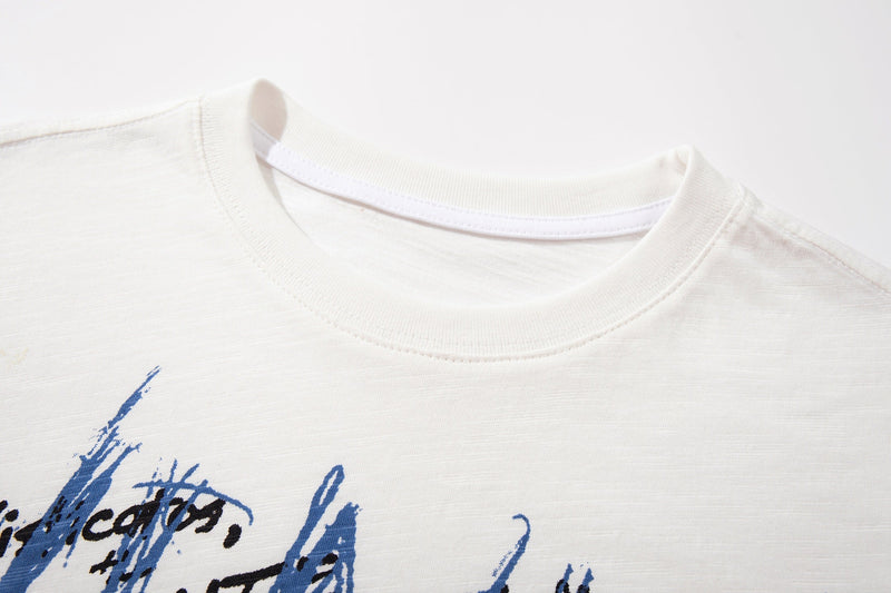White graphic T-shirt with abstract blue and black brushstroke sketch print on the chest