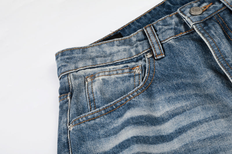 Close-up of front pocket and waistband on faded blue baggy jeans