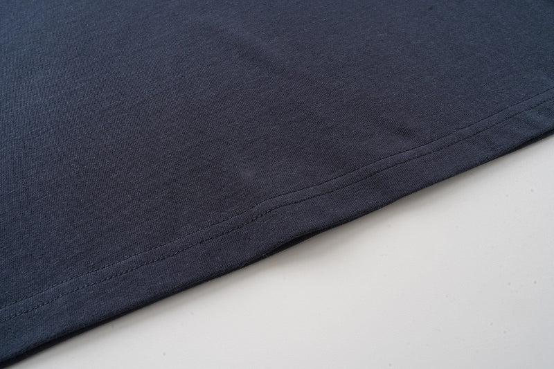 Dark navy graphic T-shirt hem with clean double stitching and soft cotton fabric detail