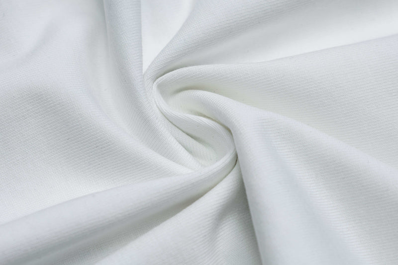 White graphic tee fabric close-up with soft folds and ribbed texture, styled for retro streetwear comfort