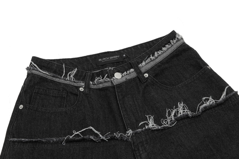Close-up of black denim shorts waistband with frayed trim, button closure, and pocket details