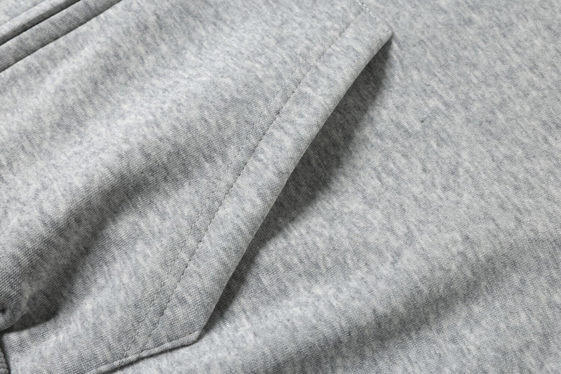 Close-up of light gray hoodie kangaroo pocket with soft fabric texture
