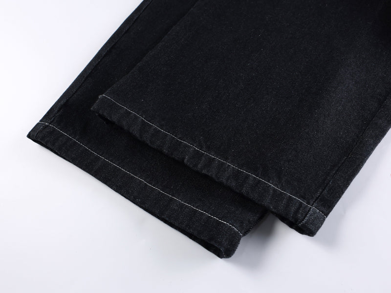 Close-up of black denim hem with white topstitching