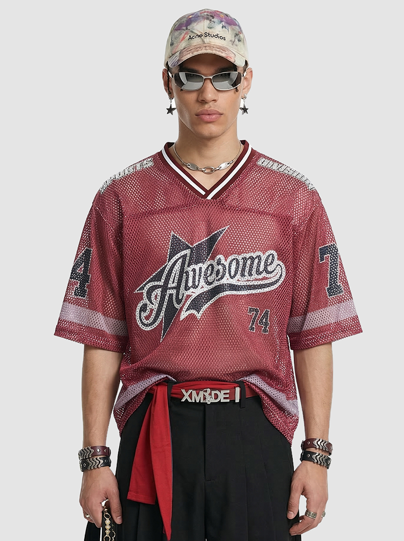 Model wearing a burgundy mesh jersey T-shirt with retro varsity graphics, number 74, and white striped trim