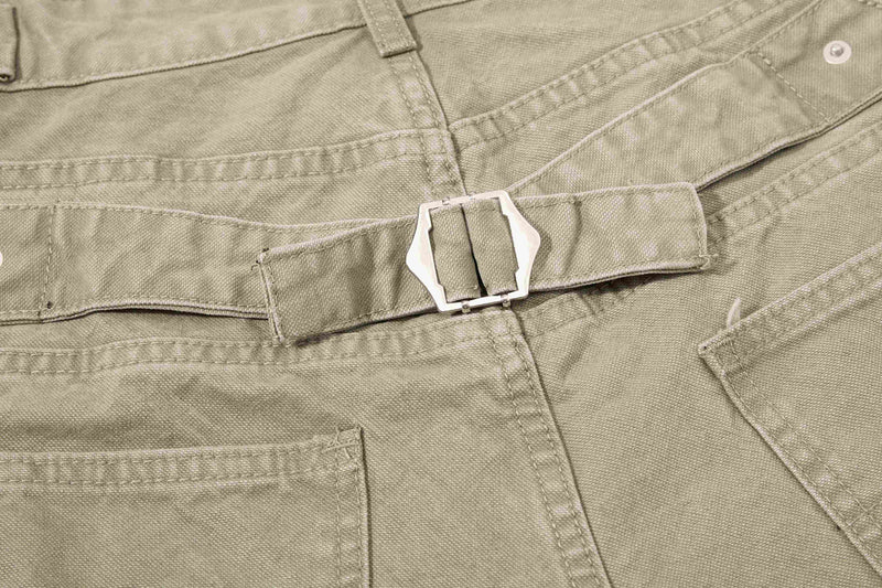 Close-up of olive green denim shorts waistband belt buckle and button fly