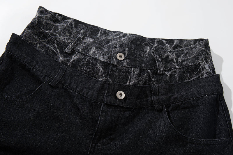 Close-up of black denim waistband with cracked panel trim and two button closures
