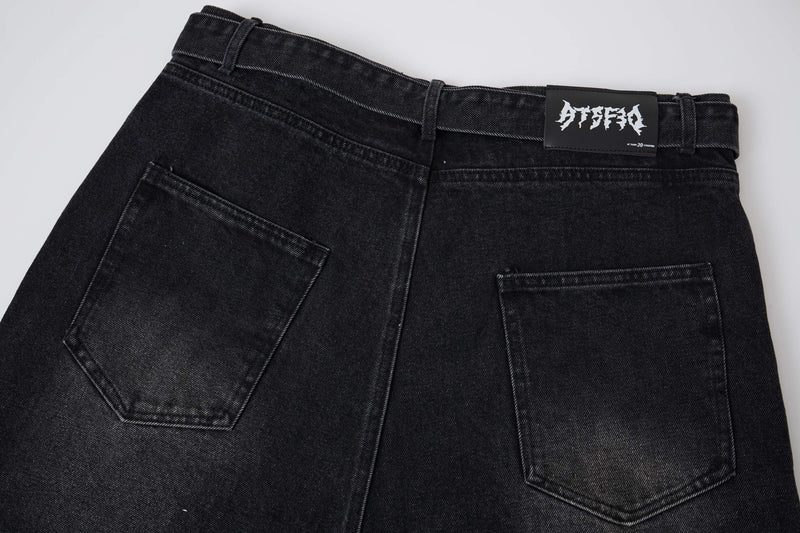 Close-up of black denim shorts back pockets and logo waistband patch