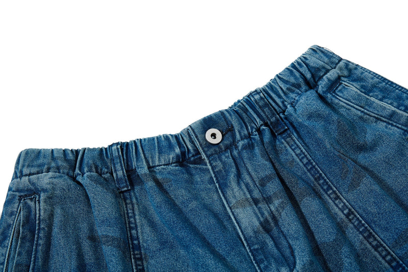Close-up of elastic waistband and snap button on washed blue camo jeans