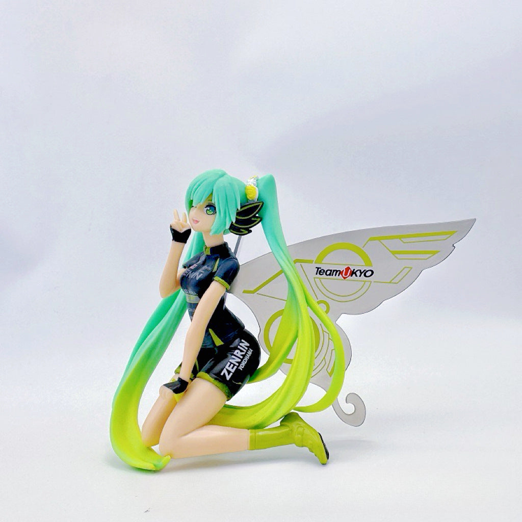 The Racing Butterfly Hatsune Miku 12cm PVC Figure by Vocaloid features a kneeling, long green-haired character transitioning to yellow, wearing &quot;TEAMUKYO&quot; attire with large wing-like structures, capturing Hatsune Miku&