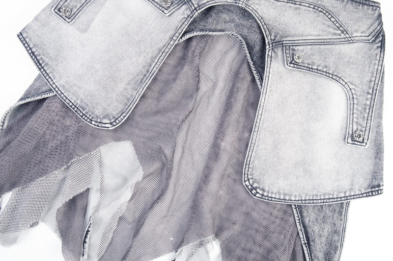Close-up of layered cargo flap pockets and mesh panels on gray denim