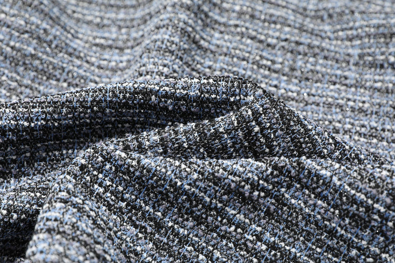 Close-up of speckled blue-gray knit fabric with a folded seam detail