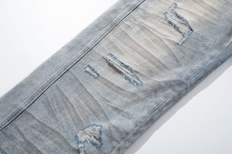 Close-up of ripped lower leg on light wash wide-leg jeans with frayed distressing