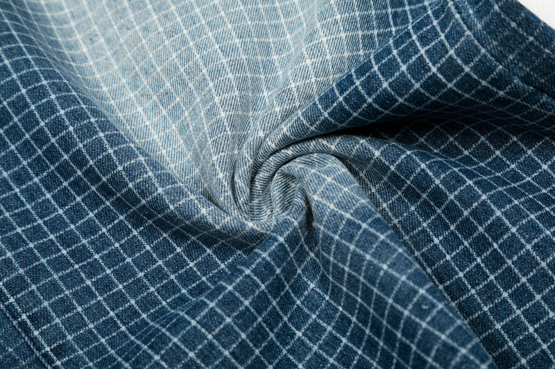 Gathered close-up of washed blue grid denim fabric texture