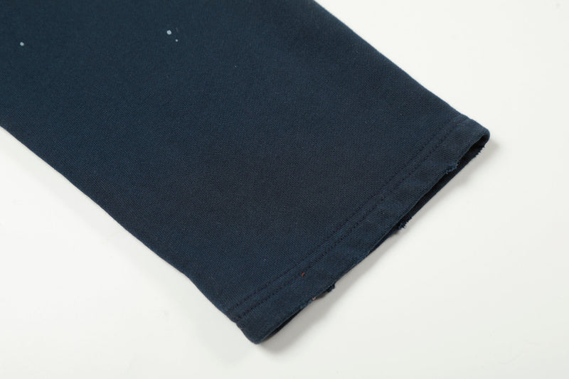 Close-up of navy sleeve cuff with small white paint specks