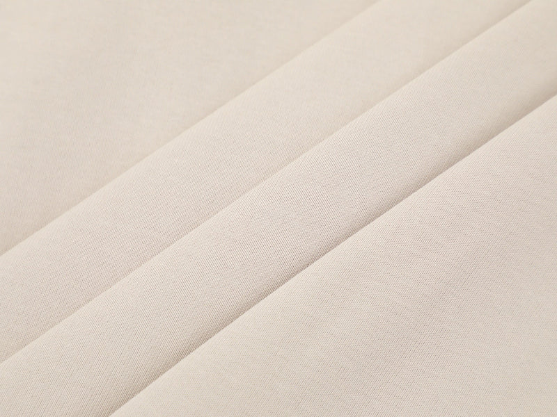 Close-up of cream fabric draped in diagonal folds
