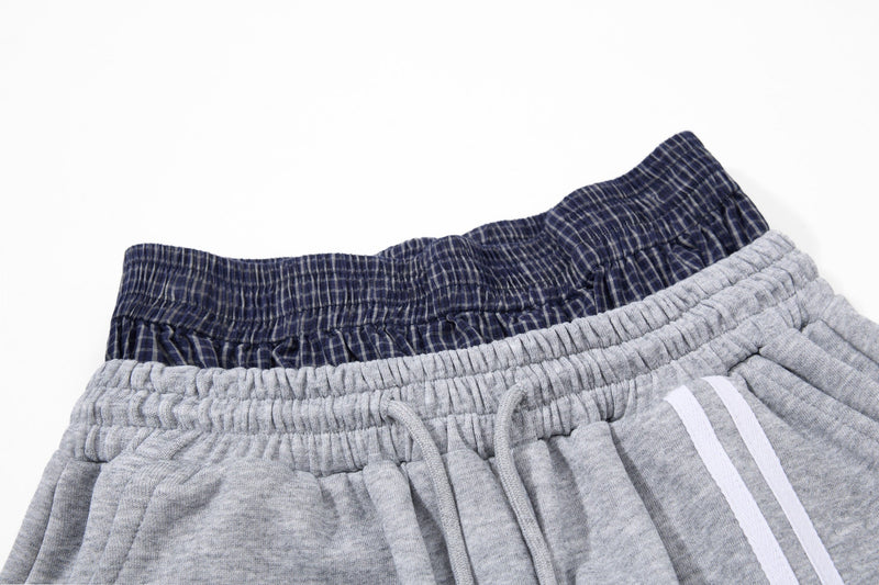 Close-up of light gray and navy layered waistbands with white stripe detail