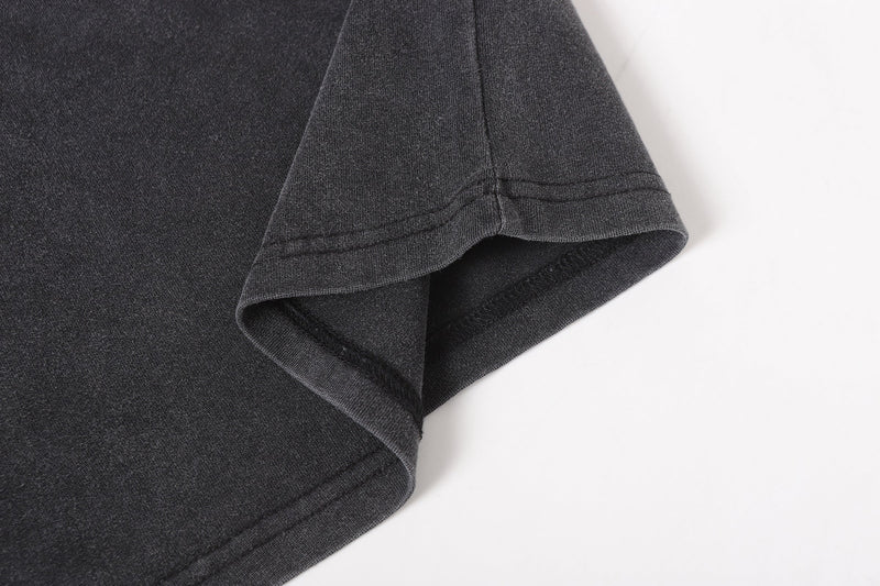 Close-up of black tee sleeve cuff and hem with washed fabric texture