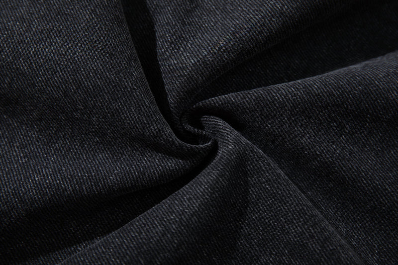 Close-up of dark denim fabric texture with soft folds