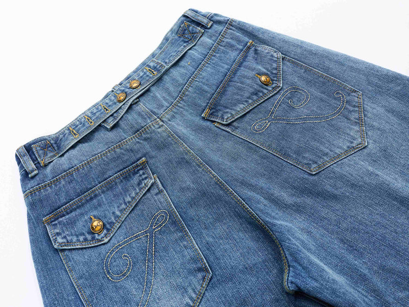 Back view of blue denim shorts showing both rear pockets and embroidered swirl stitching
