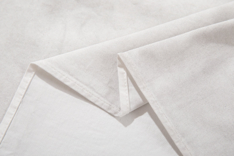 Close-up of white short sleeve shirt fabric with folded hem and subtle texture detailing
