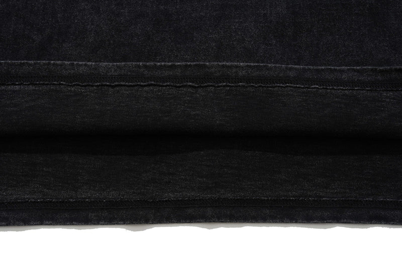 Close-up of a black washed polo shirt hem with distressed texture and visible seam stitching