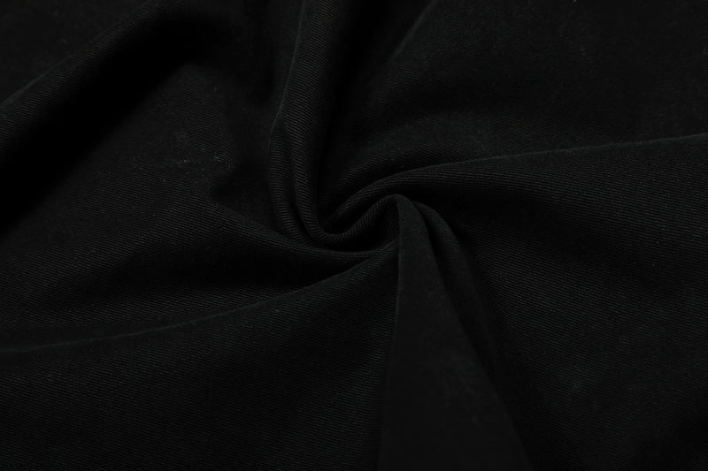 Close-up of black pant fabric with soft folded texture