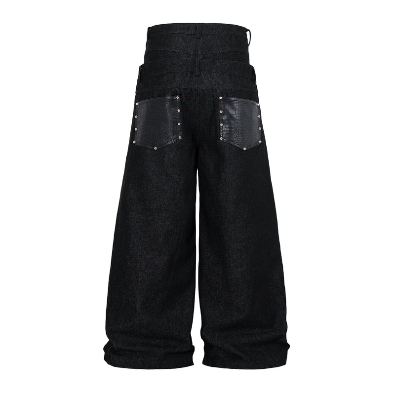 Rear view of black wide-leg denim pants showing stacked waistband details and textured back pockets