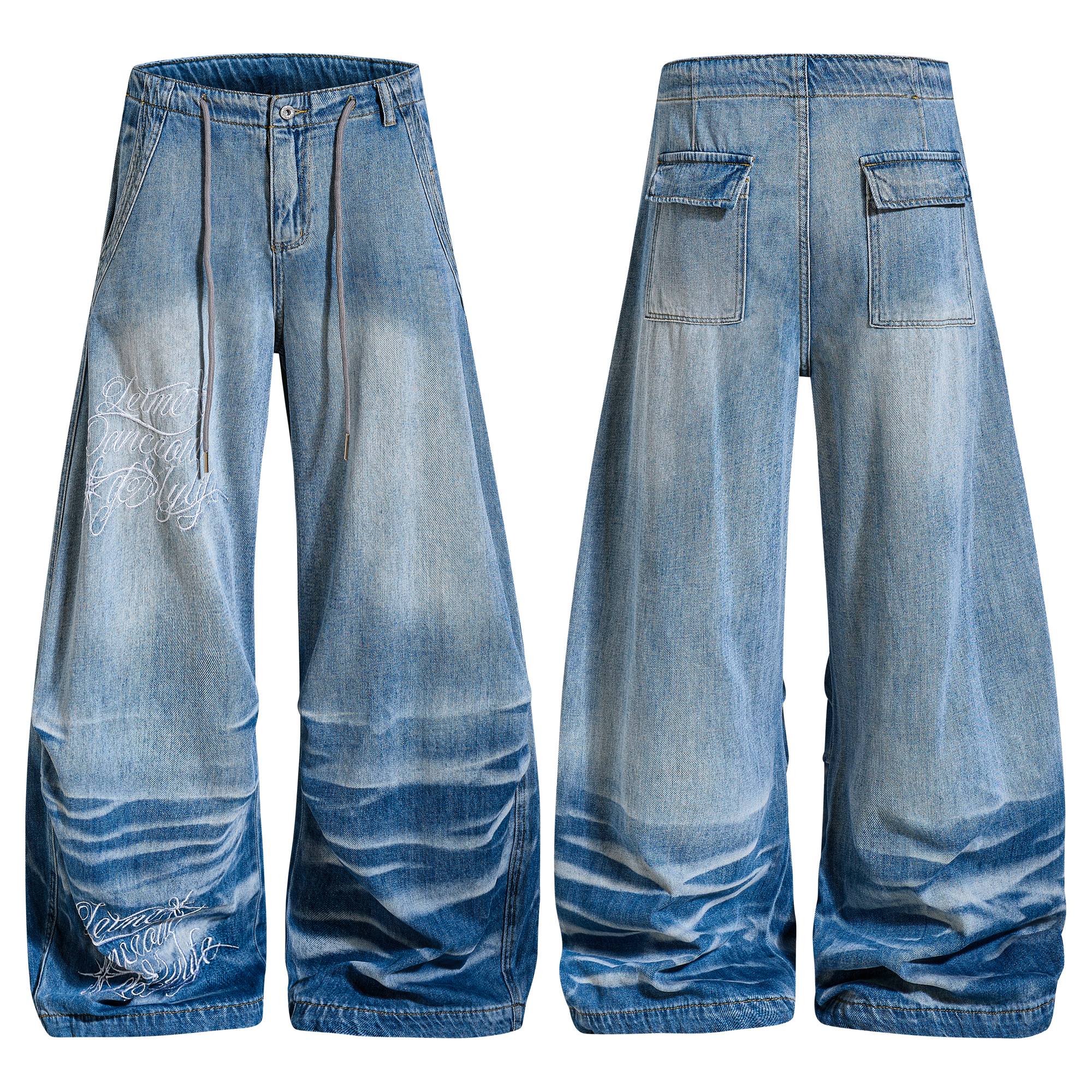 Front and back view of Omirad vintage wash super baggy wide-leg jeans with embroidered script graphics and stacked hem