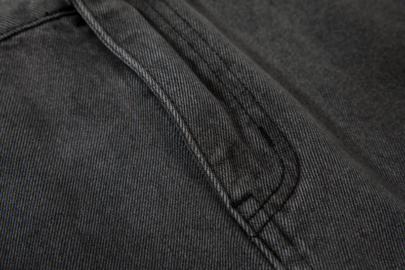 Close-up of black denim seam stitching with smooth washed texture