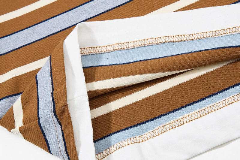 Close-up of a vintage striped varsity tee with brown, blue, and white panels and visible embroidered stitching