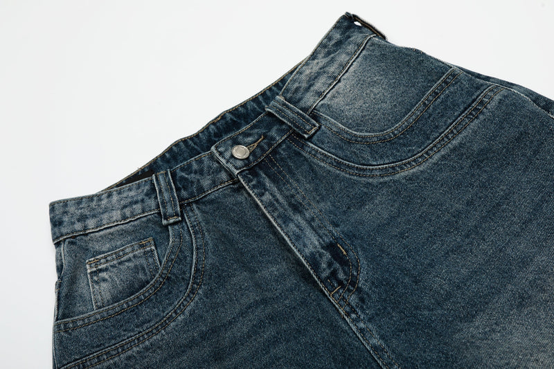 Close-up of front waist and pocket area on blue vintage wash denim shorts