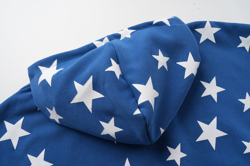 Close-up of blue star-print hoodie fabric draped across the hood and chest