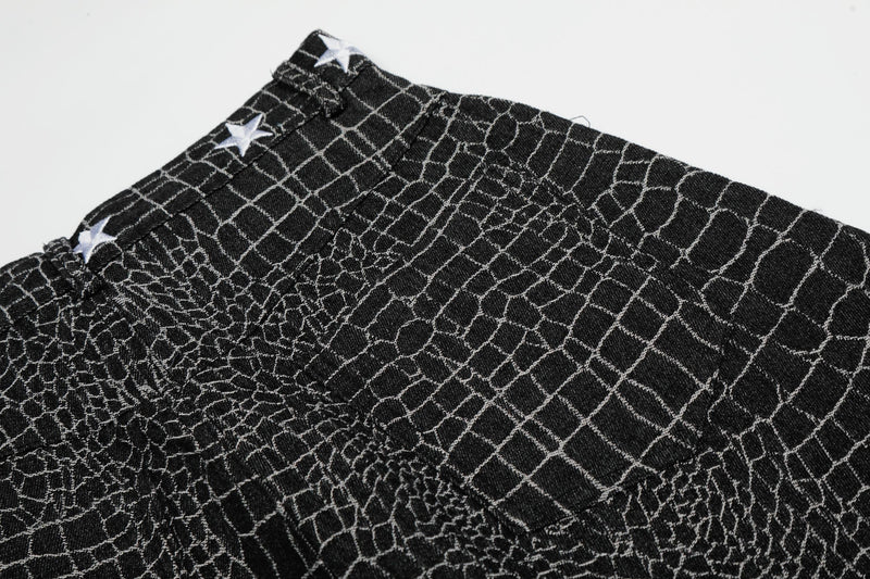Close-up of black pants waistband and textured crocodile-style pattern