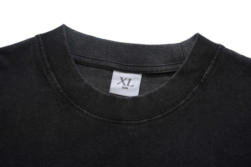 Black oversized graphic tee with ribbed crew neckline and XL size label, shown in a close-up front view