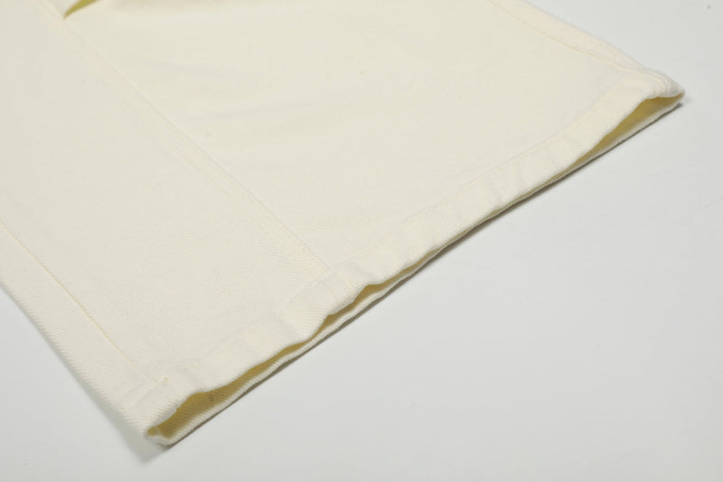 Close-up of cream cargo pants hem and stitched cuff detail