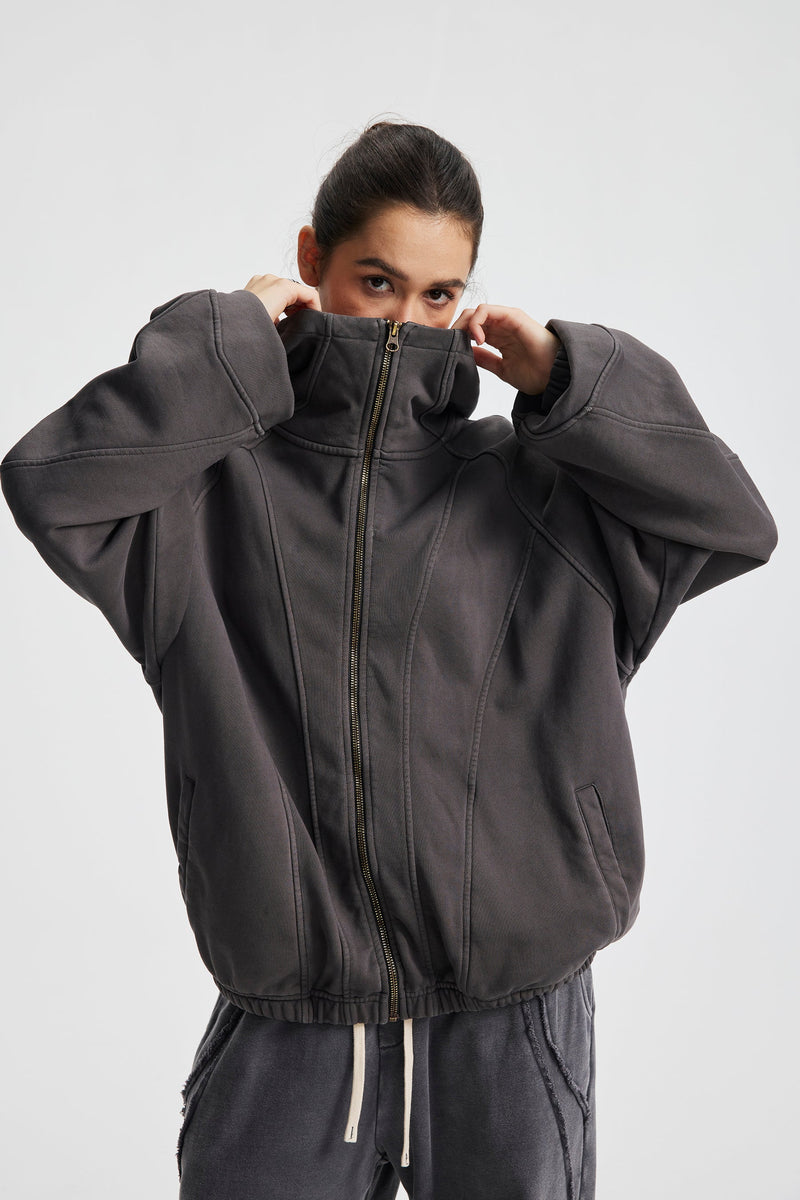 Close front view of charcoal gray hoodie pulled up to the chin on a model