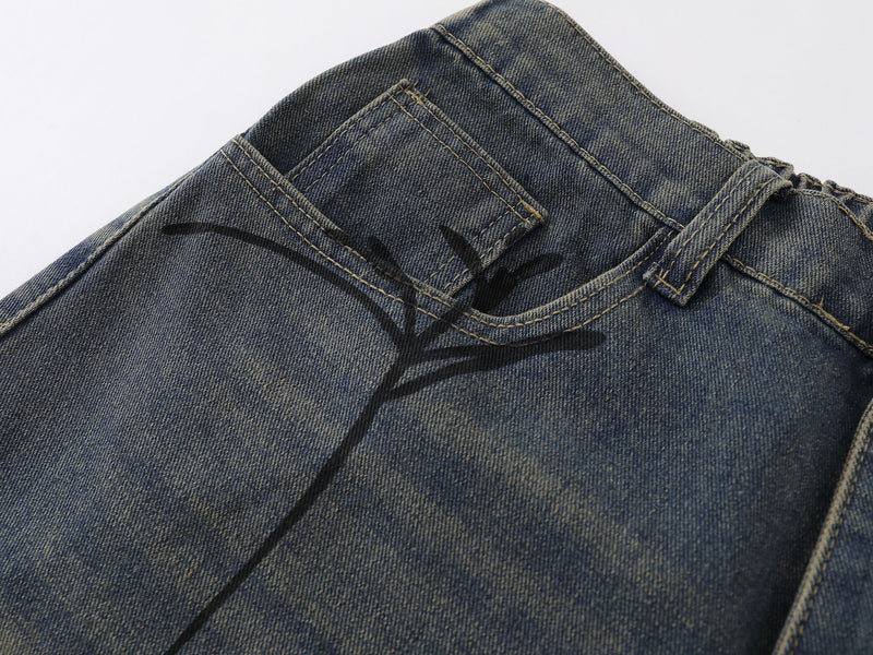 Close-up of front pocket and spider web graphic on faded blue denim shorts