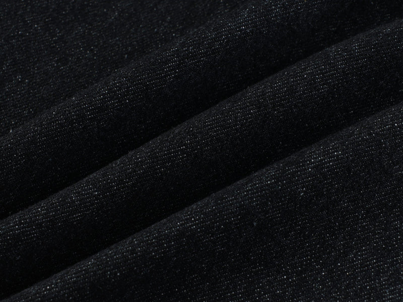 Close-up of dark wash denim fabric texture with fine speckled weave