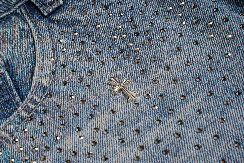 Close-up of light wash jeans front pocket and silver star detail