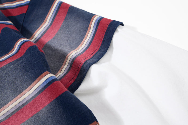 Close-up of long sleeve and hem in navy shirt with red, blue, and cream stripes