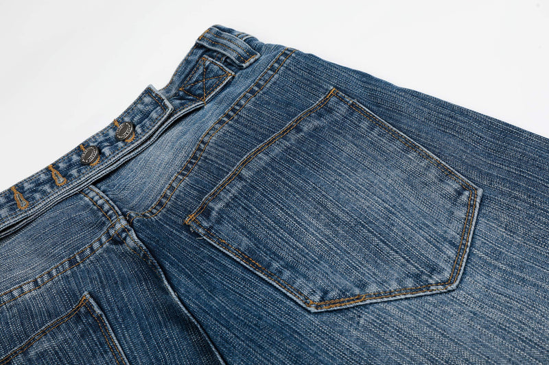 Close-up of the back pocket and waist buttons on blue denim jeans