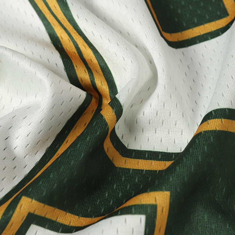 Close-up of white mesh varsity football jersey fabric with green and gold striped number detailing