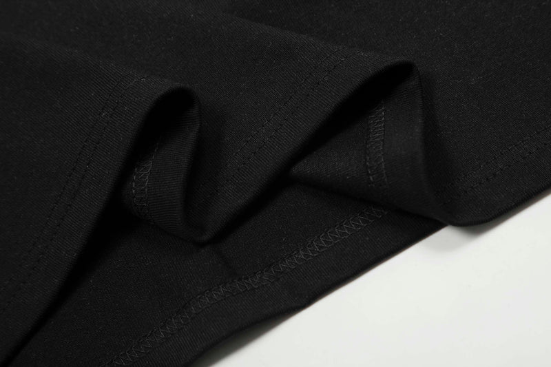 Close-up of black T-shirt fabric with visible stitched seams and folded hem detailing