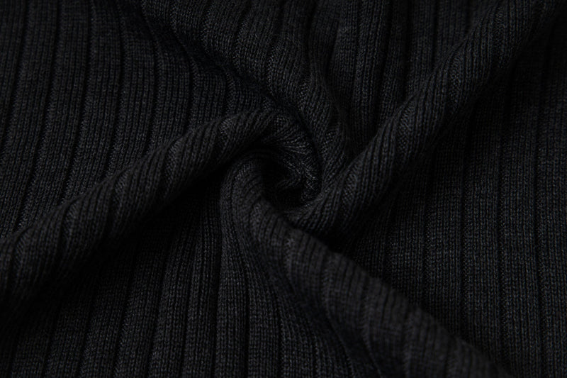 Close-up of gathered black ribbed knit fabric showing vertical stretch texture
