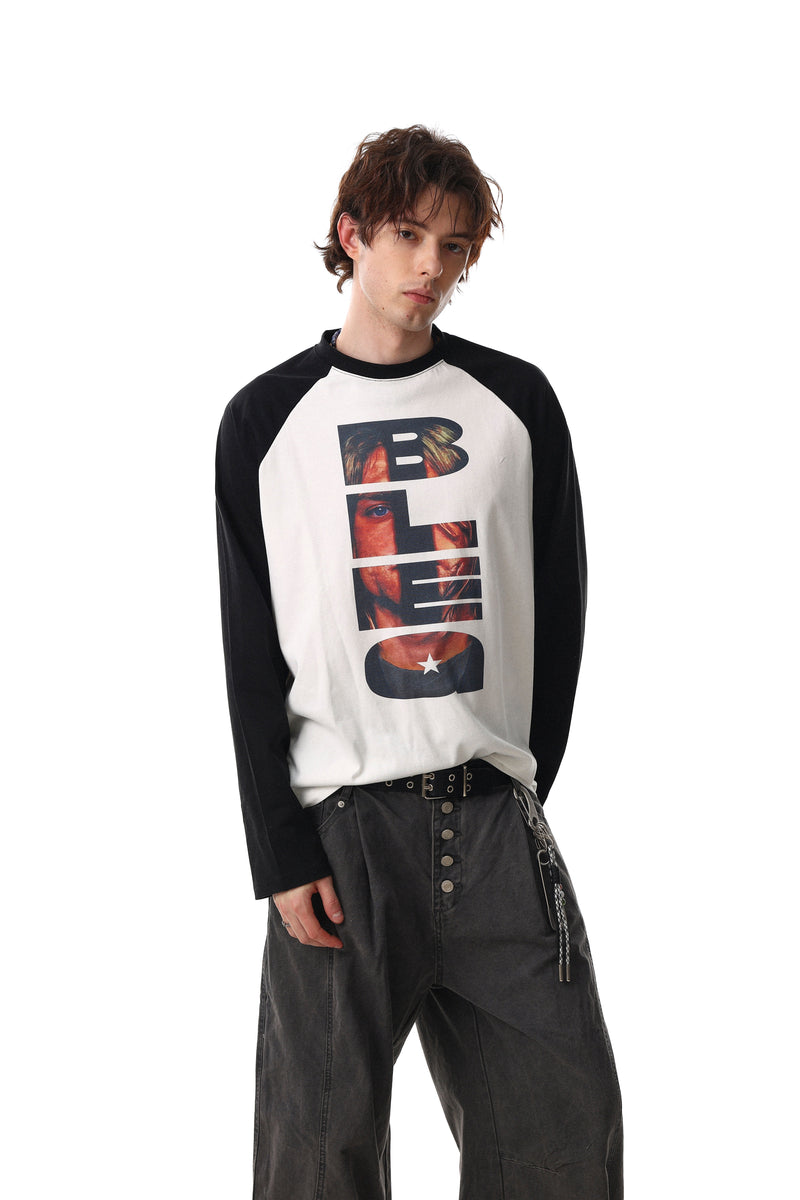 Close-up of model wearing black and white raglan tee with vertical portrait print on the chest