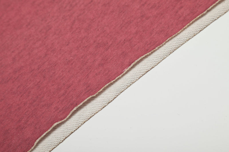 Close-up of pink hoodie hem with white overlock seam detail