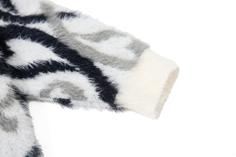 Close-up of black and white faux-fur sleeve cuff with cream ribbed edge