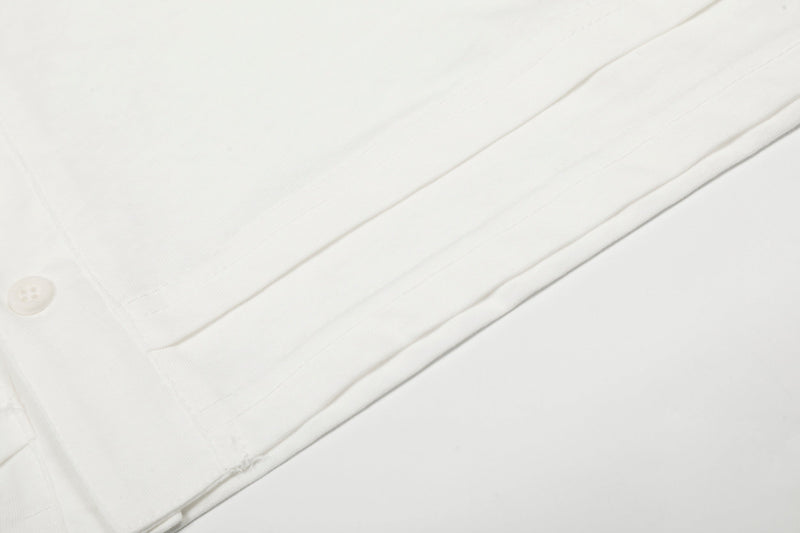 Close-up of white tee side seam and lower hem with visible stitching