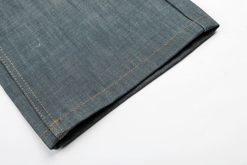 Close-up of the hem on washed grey denim jeans with contrast topstitching