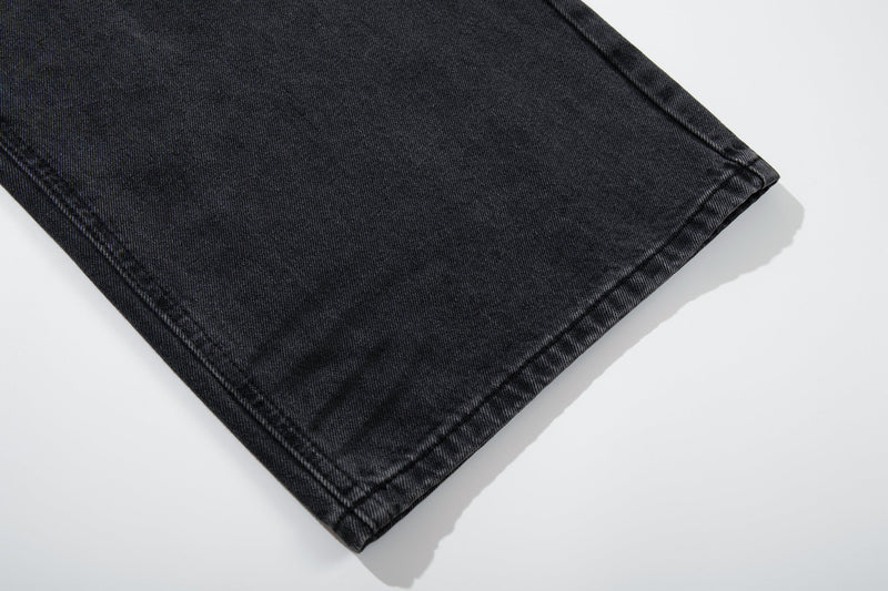 Close-up of hem on black faded wide-leg jeans with clean stitched edge